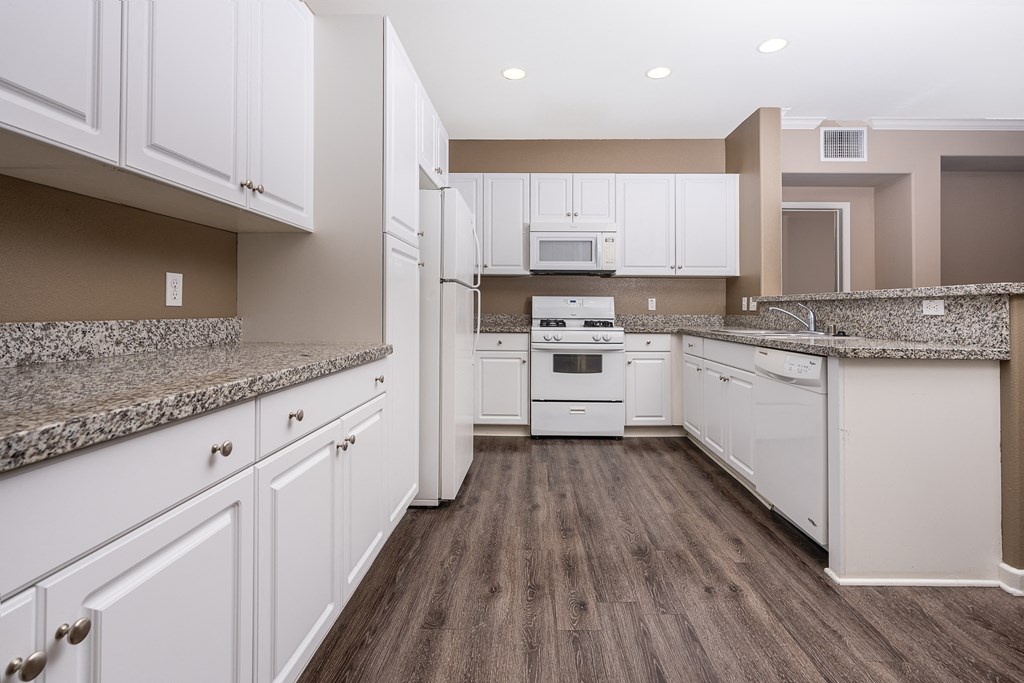 a kitchen with white cabinets and white appliances