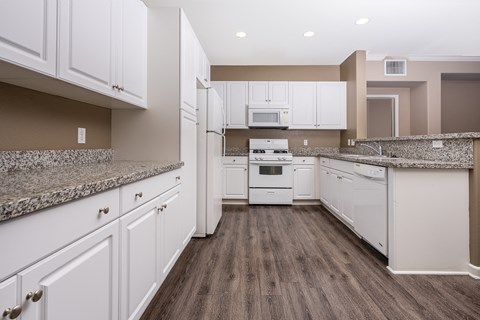 a kitchen with white cabinets and white appliances