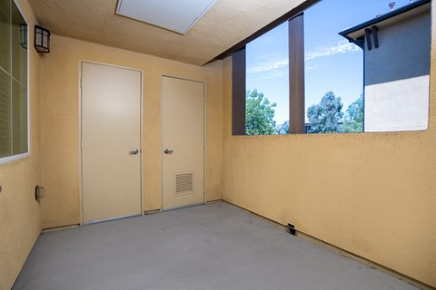 an empty room with a large window and two doors