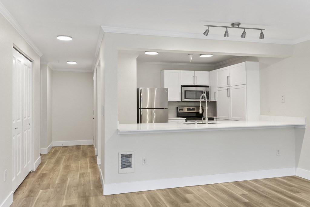 a kitchen with white cabinetry and a white counter top and stainless appliances at Lakemont Orchard, Issaquah