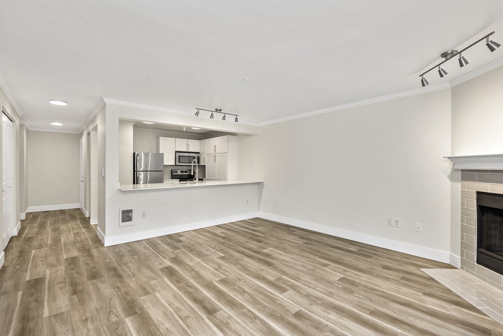 a living room with wood style flooring and views of kitchen