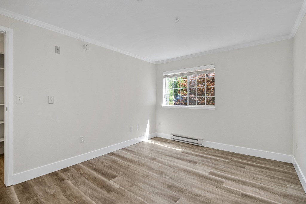 a bedroom with white walls and a window