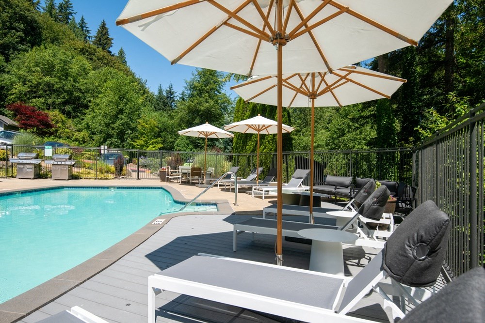 a swimming pool with tables and umbrellas next to it at Lakemont Orchard, Washington
