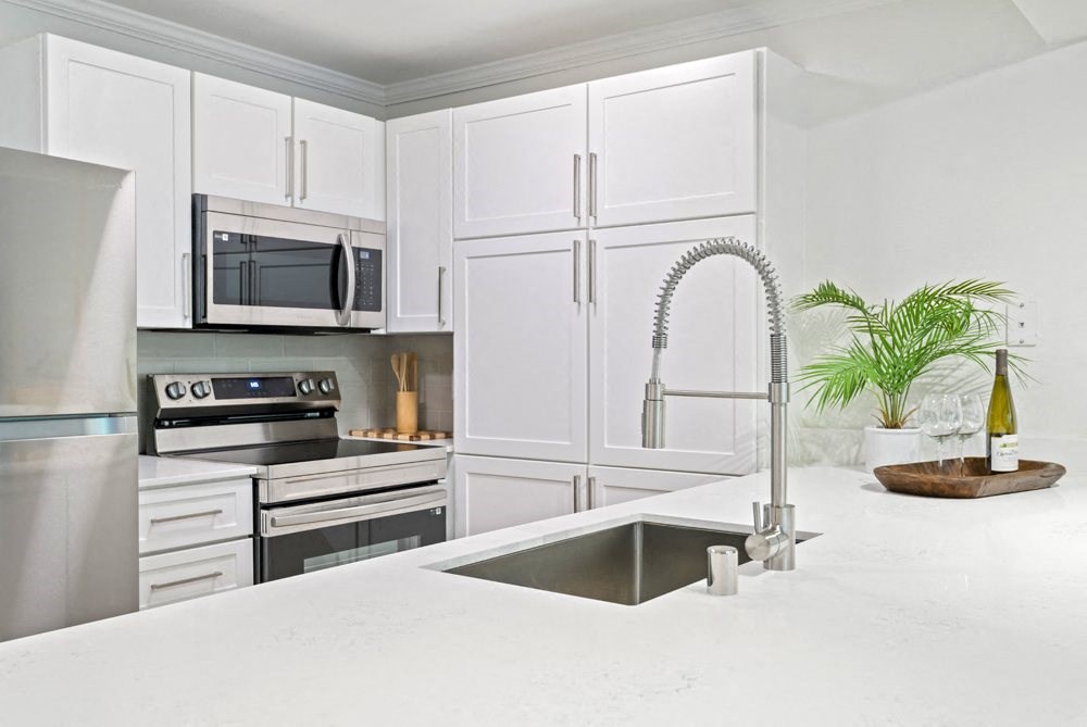 a white kitchen with stainless steel appliances and a sink at Lakemont Orchard, Issaquah, WA