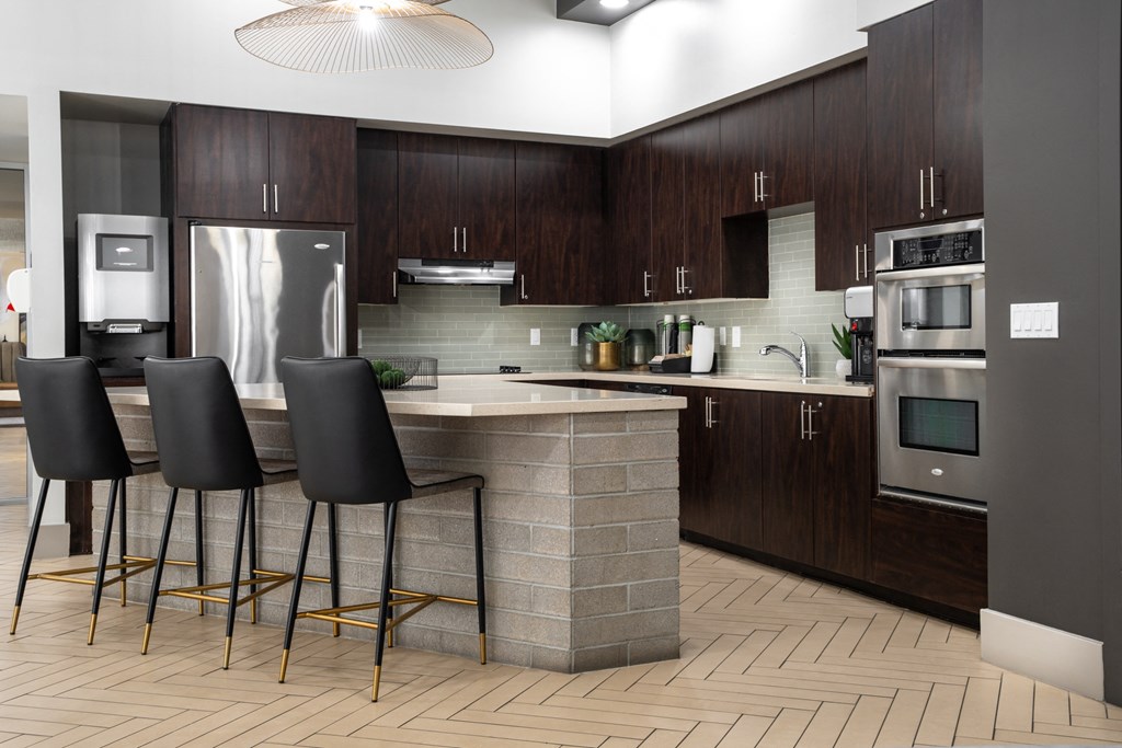 a kitchen with a large island with four chairs in front of it