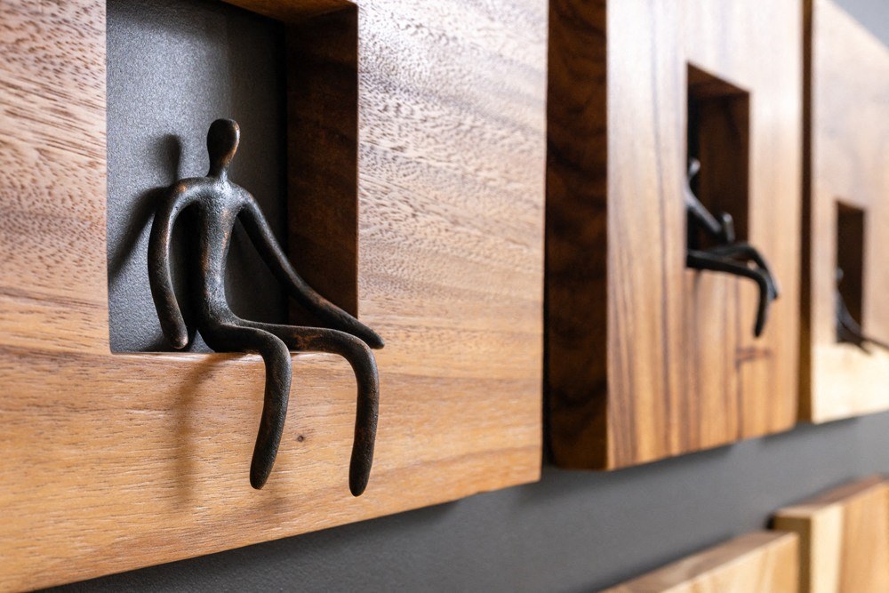 aulpture of a person sitting on a wall next to a mirror