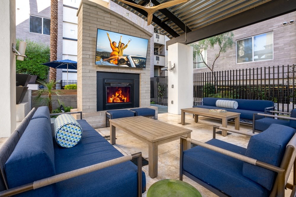 a patio with couches and tables and a fireplace