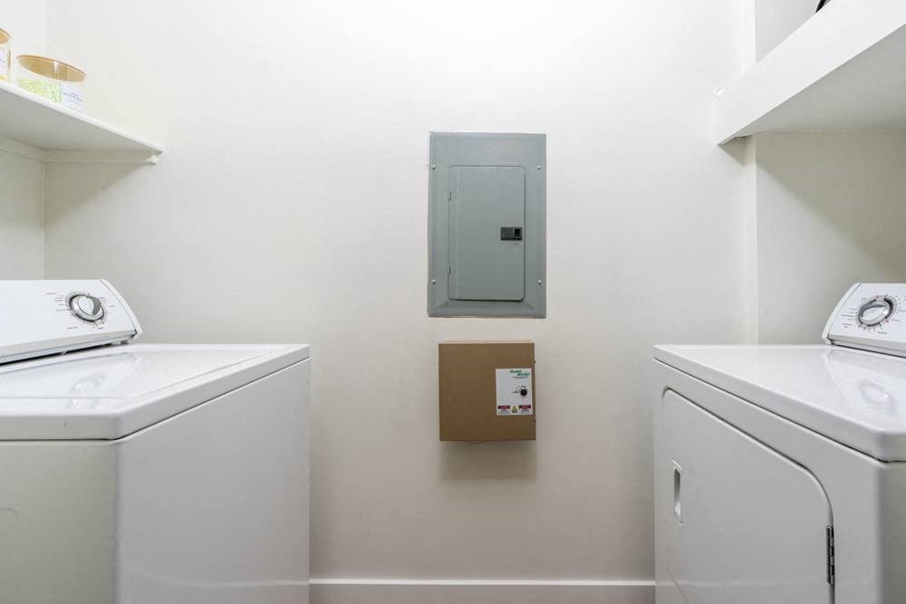 a washer and dryer in a laundry room with a box on the wall