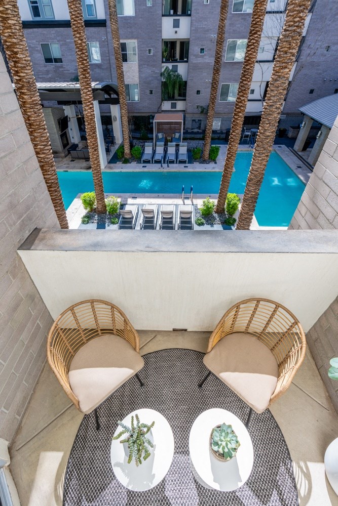 a patio with chairs and tables and a swimming pool