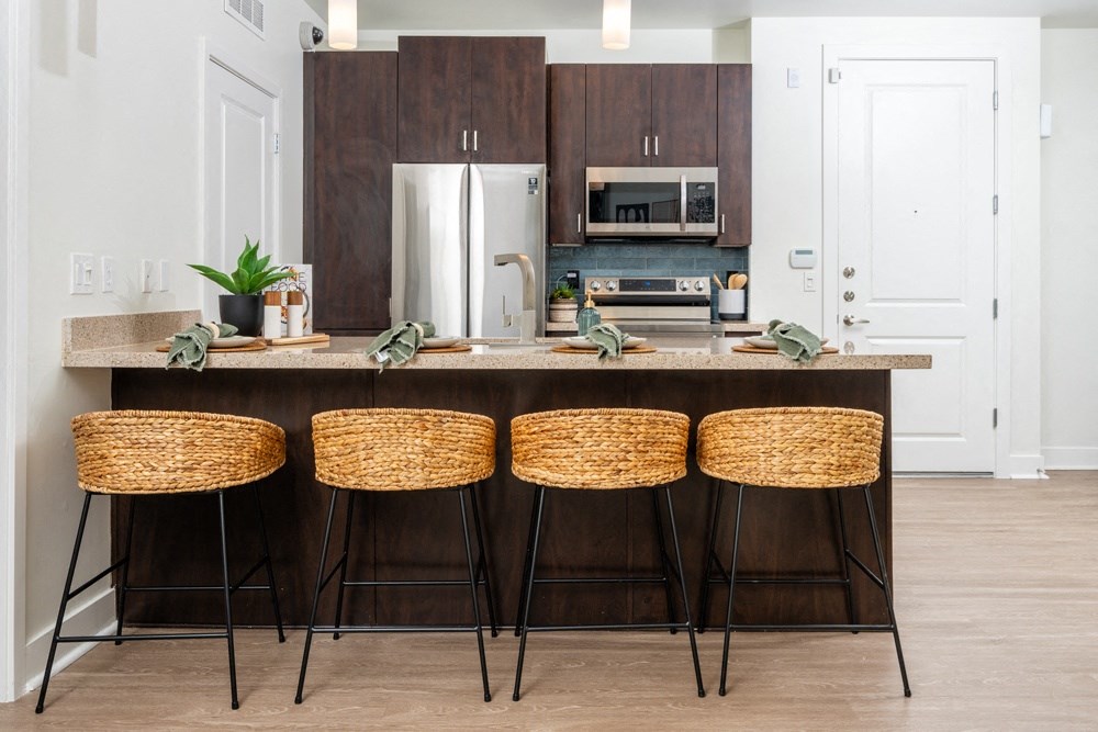 a kitchen with wooden cabinets and a counter with four stools