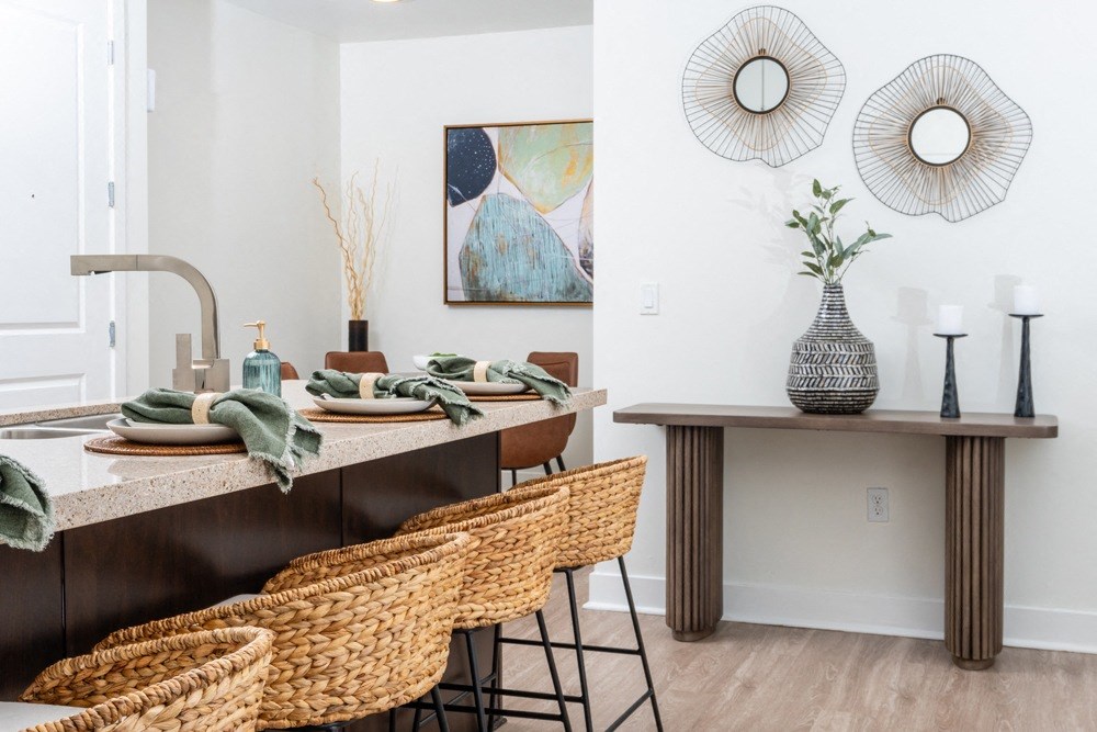 a dining area with a table and chairs and a counter with a sink