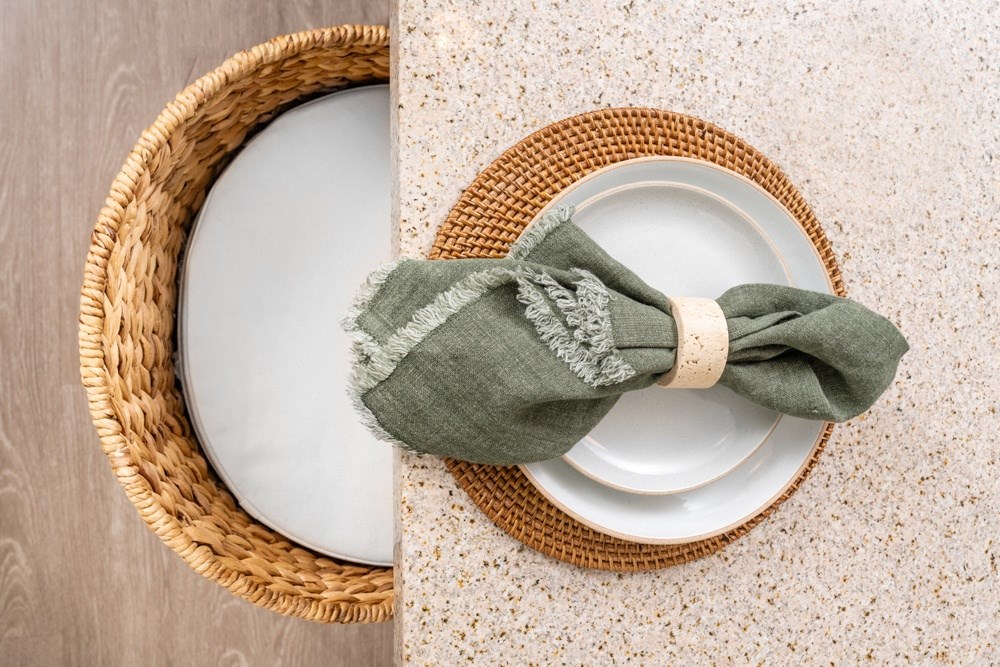 a plate with a napkin with a green napkin tie on top of it
