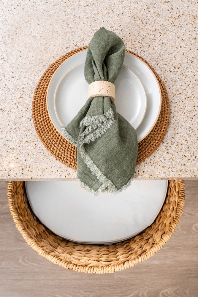 a green napkin on a white plate with a green tie on top of it