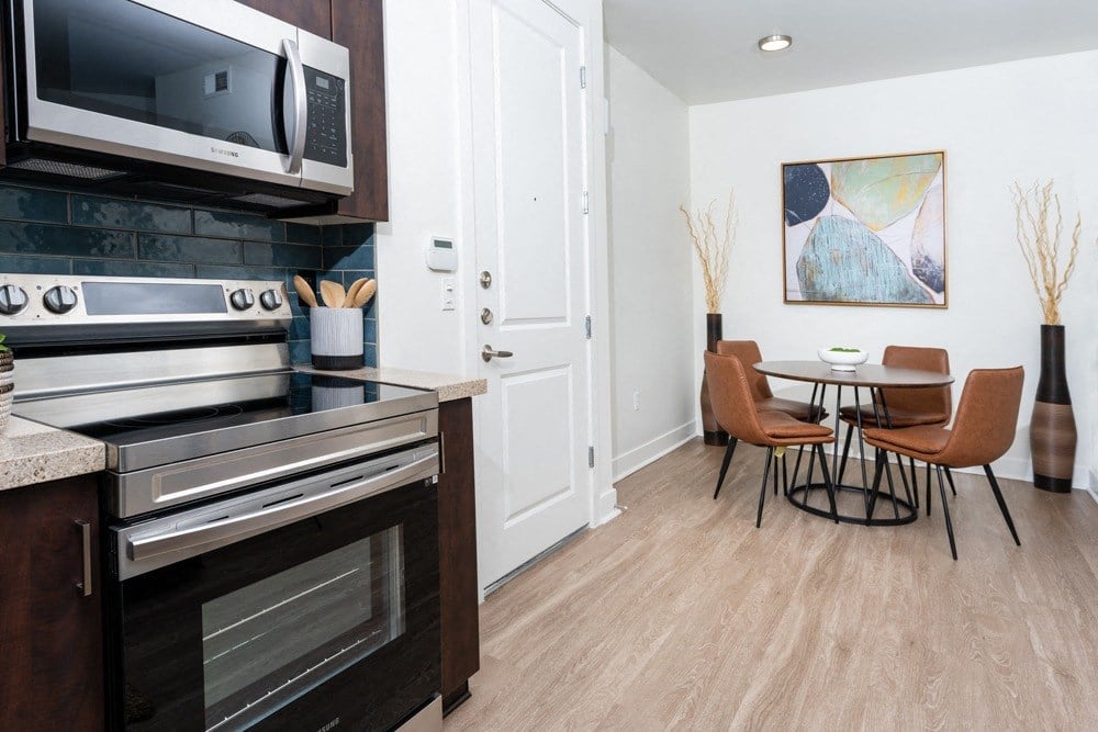 a kitchen and dining room with a microwave and a table and chairs
