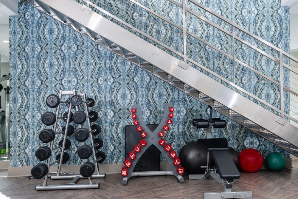 a gym with weights and a punching bag on the wall