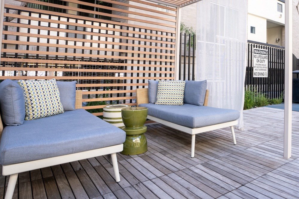 a patio with two blue couches on a wooden deck