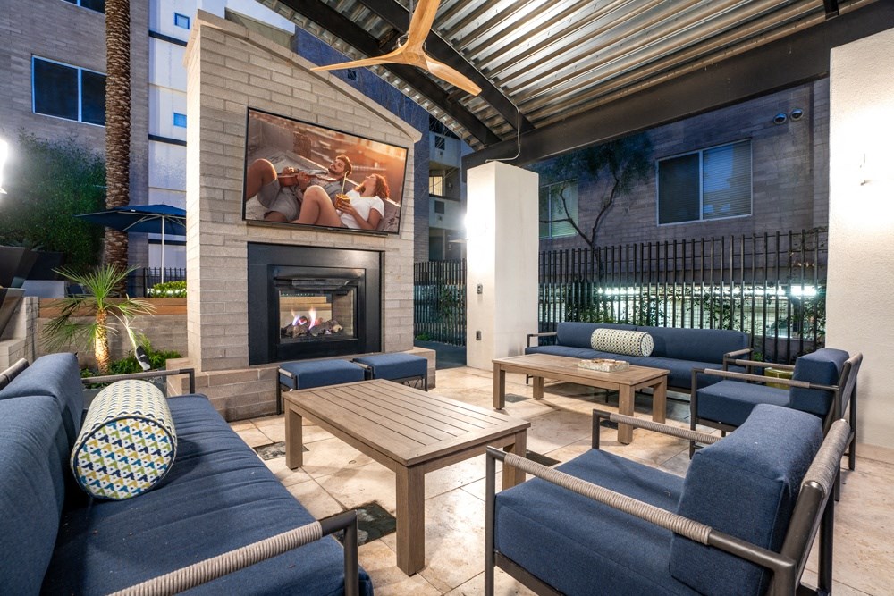 a patio with couches and tables and a fireplace