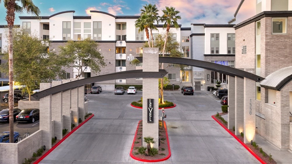 an aerial view of an empty parking lot with buildings and palm trees