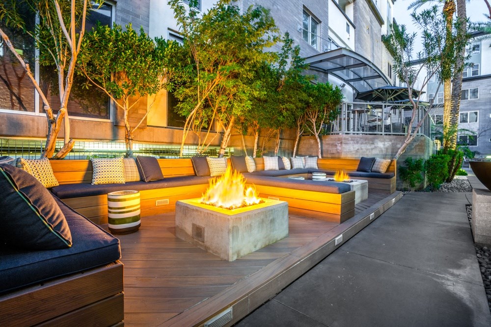a patio with couches and a fire pit