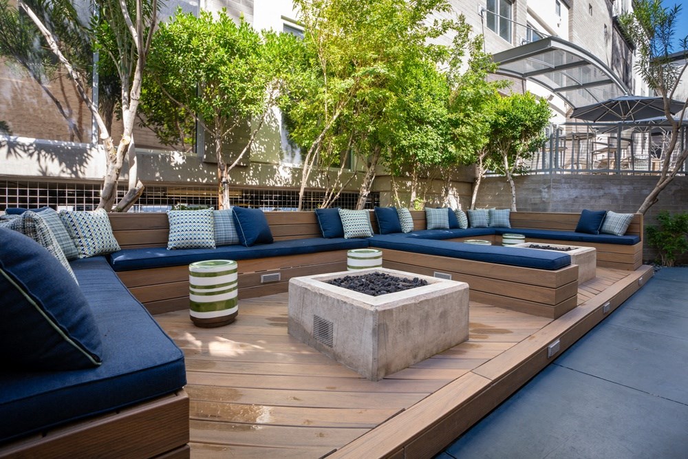 a seating area with couches and a fire pit in a courtyard