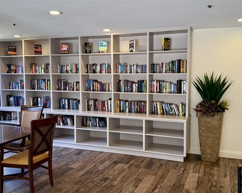 A room with a bookshelf filled with books and a chair in front of it.