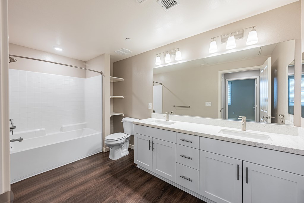 A bathroom with a white tub, toilet, and sink.
