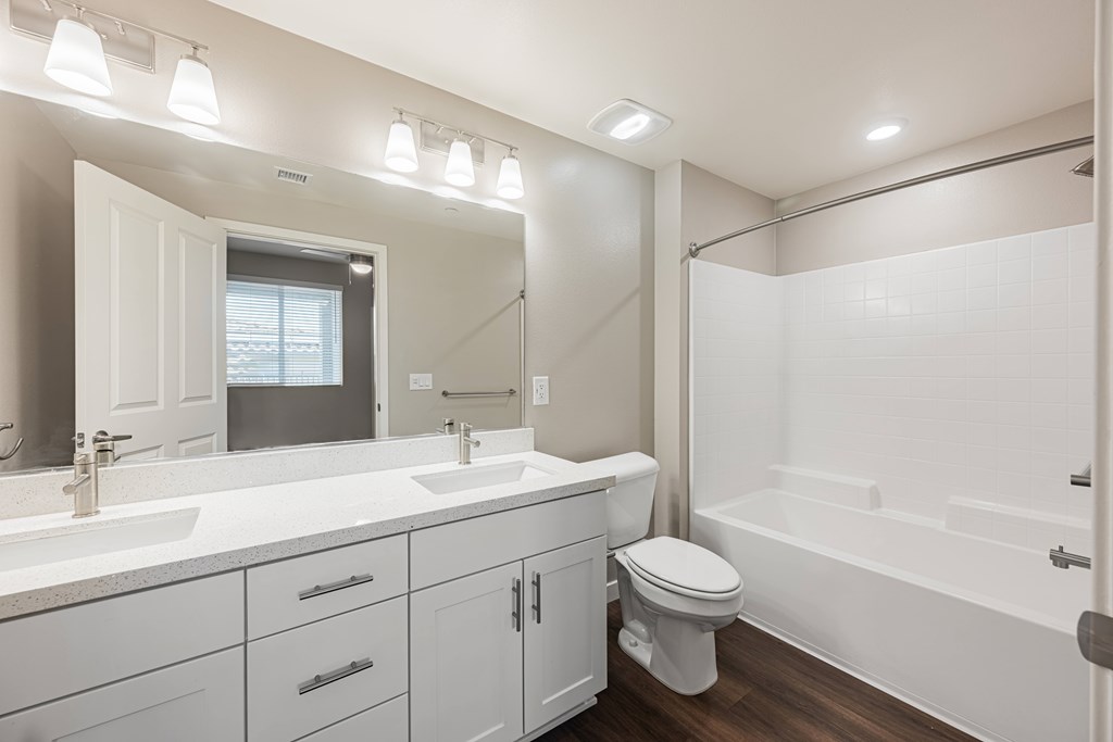 A white bathroom with a sink, toilet, and bathtub.