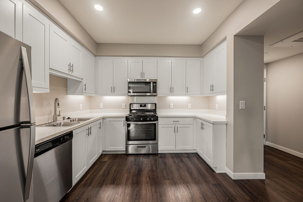 A modern kitchen with white cabinets and stainless steel appliances.