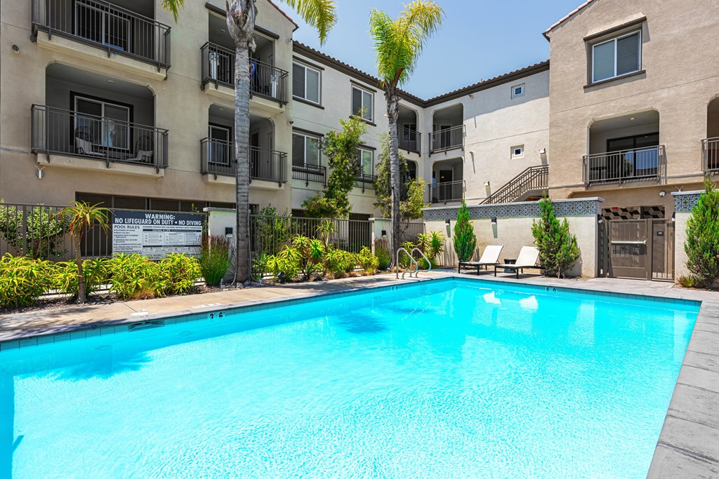 A swimming pool in front of apartment buildings.