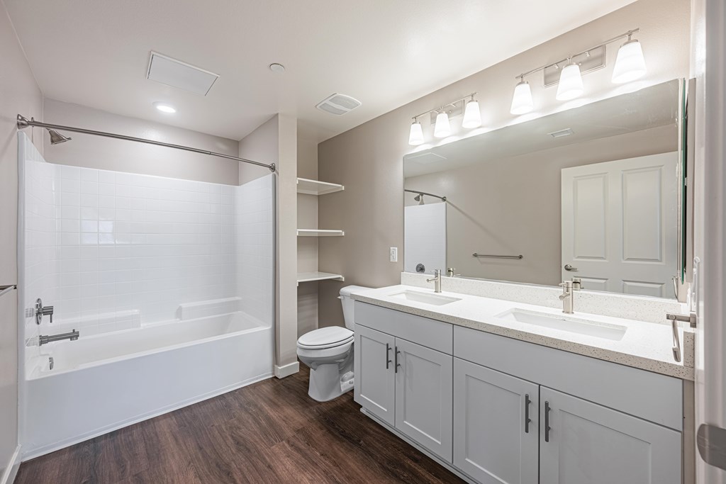 A white bathroom with a toilet, sink, and shower.