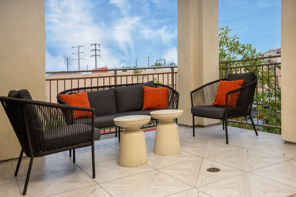 a patio with a couch and two chairs