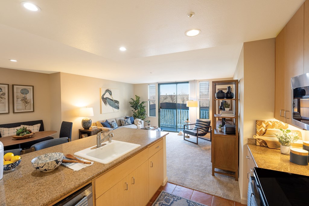 the view of a living room from a kitchen with a sink
