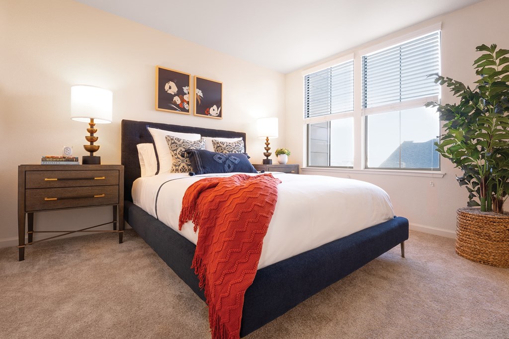 a bedroom with a bed and a window and a potted plant