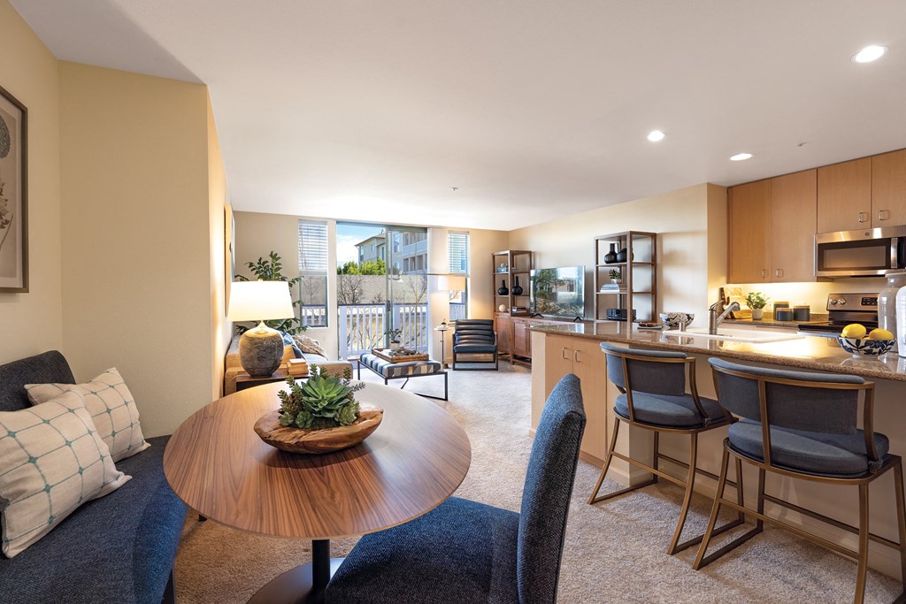 a living room and kitchen with a table and chairs