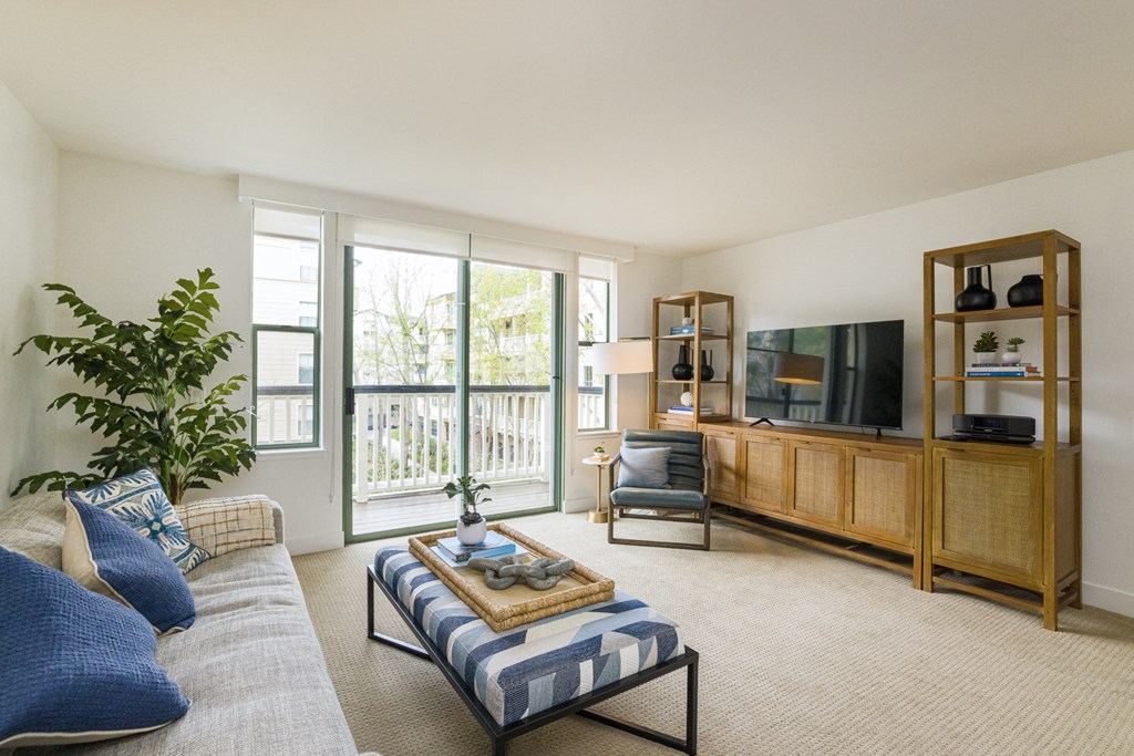 a living room with a couch and a tv and a balcony
