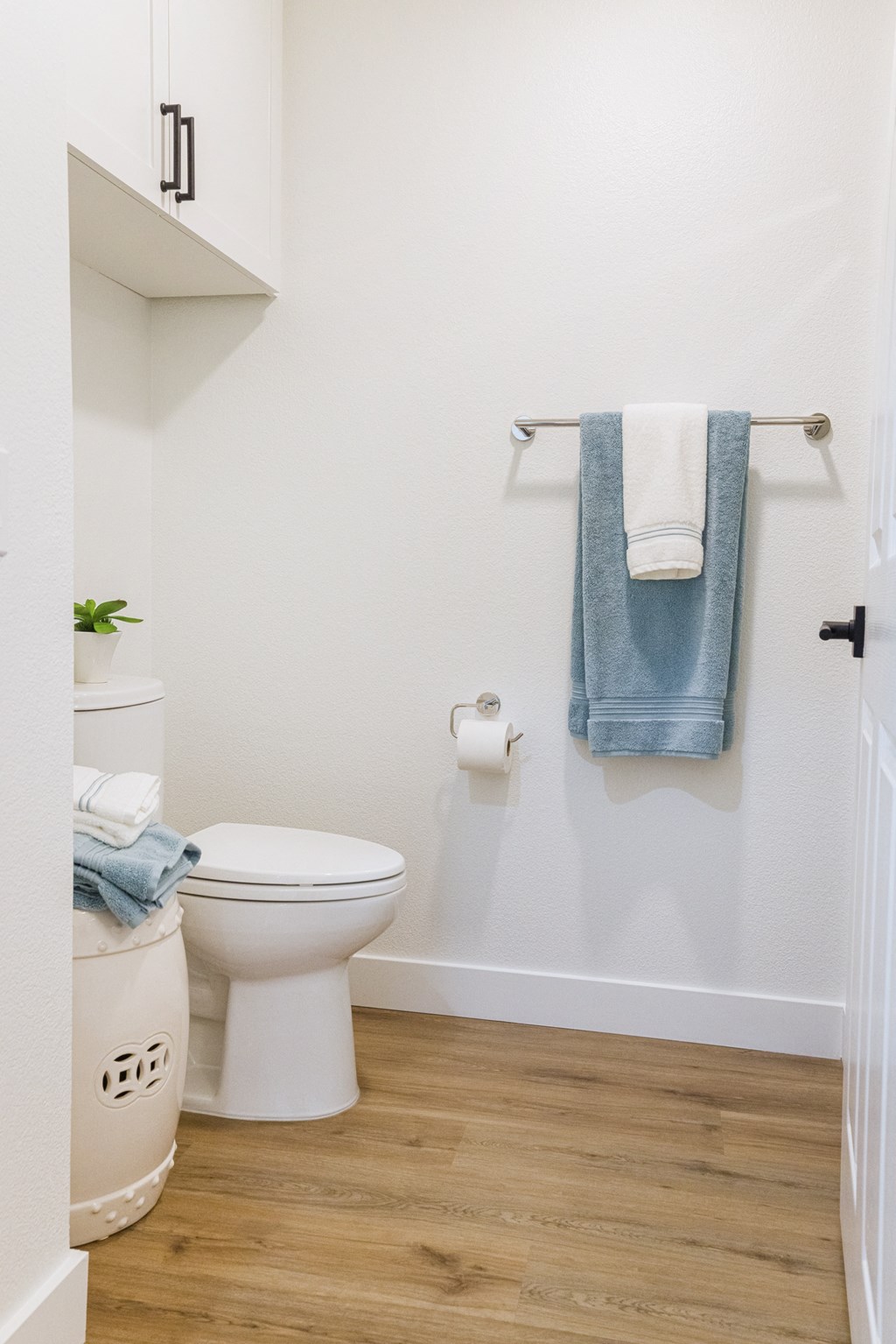 a bathroom with a white toilet and a blue towel