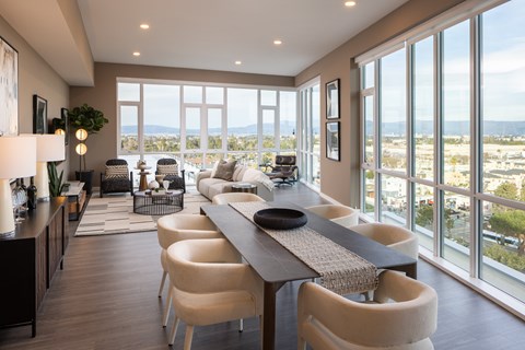 A modern dining room with a long table and chairs.