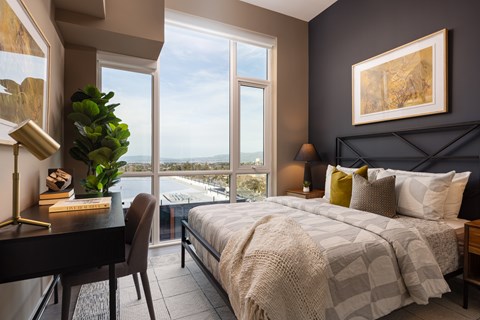 A bedroom with a large bed and a view of the city.