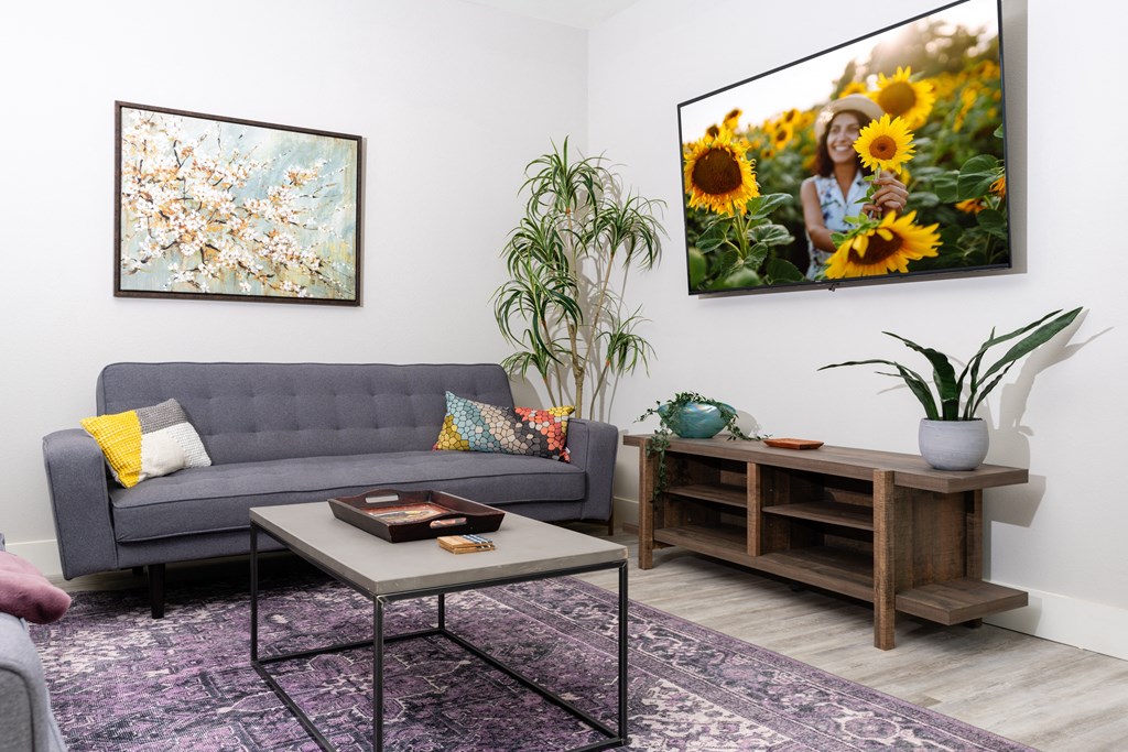 living room with a couch and a table and a picture of sunflowers at Mihir Taylor, Taylor, 76574