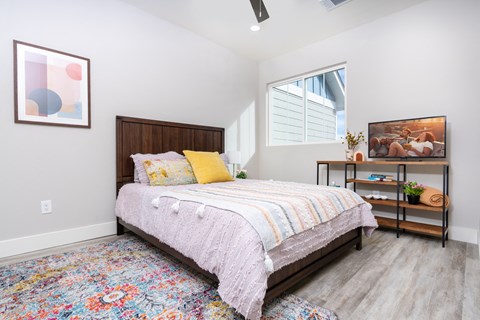 Cozy bedroom with dark wood furniture at Mihir Taylor Apartments, Texas