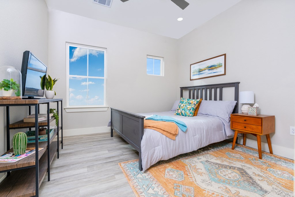 model bedroom with a bed and a desk with a tv at Mihir Taylor, Texas 76574