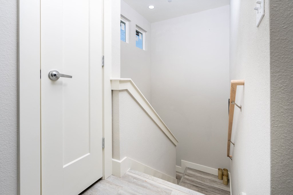 the landing of a staircase in a home with white walls and a door at Mihir Taylor, Texas