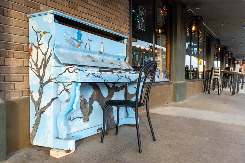 a piano outside of a restaurant with a chair at Mihir Taylor, Taylor