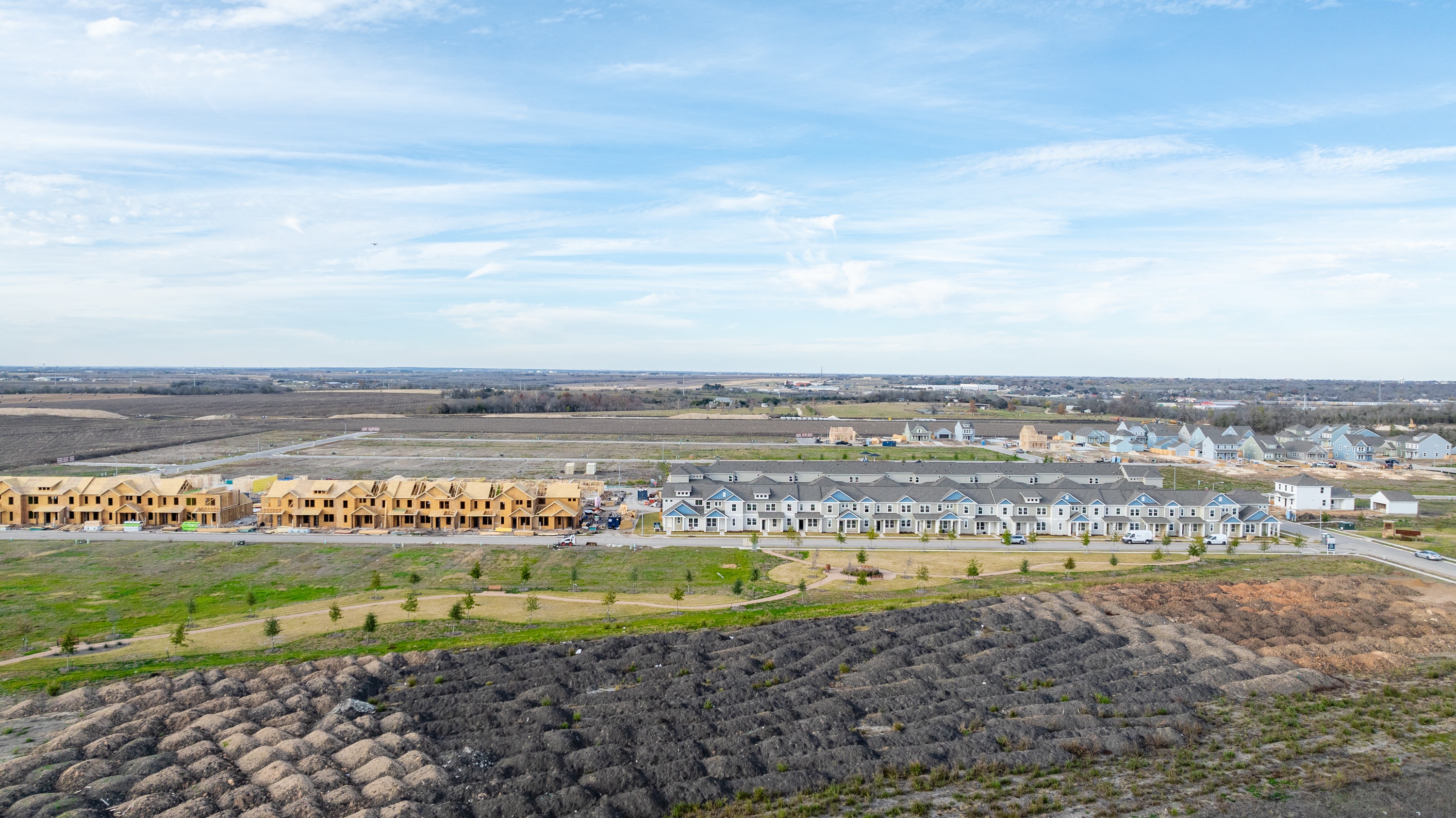 an aerial view of mihir taylor neighborhood and a field of trees