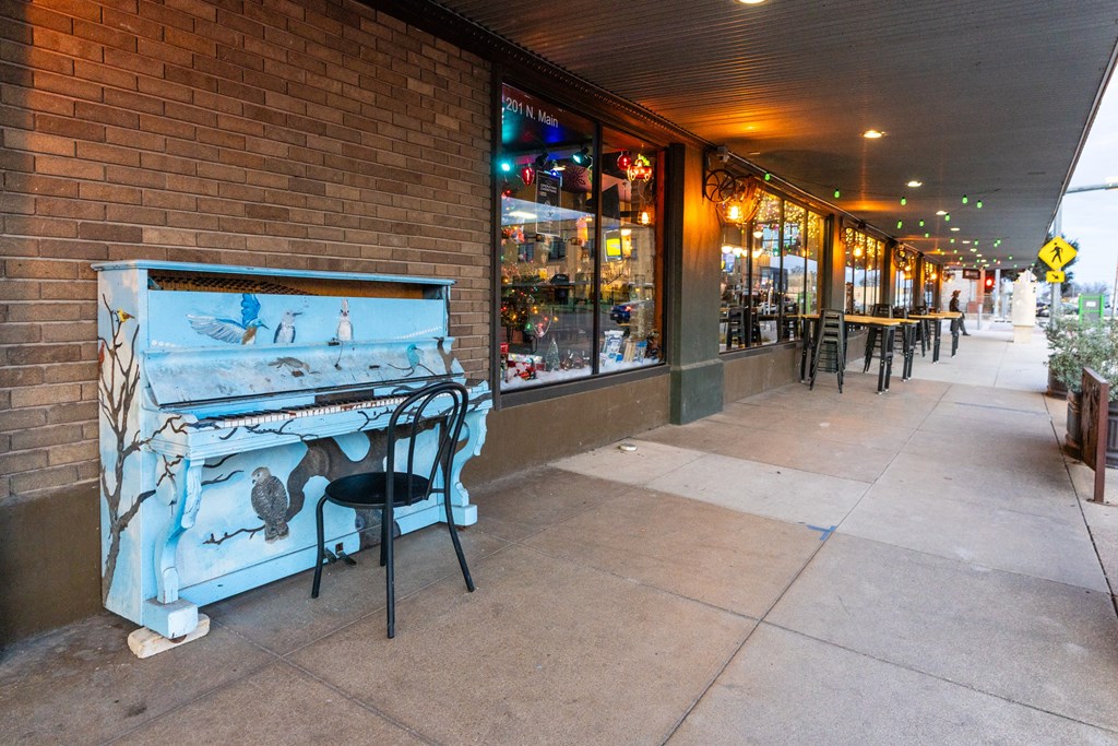 a blue piano on the sidewalk outside a store at Mihir Taylor, Taylor, 76574