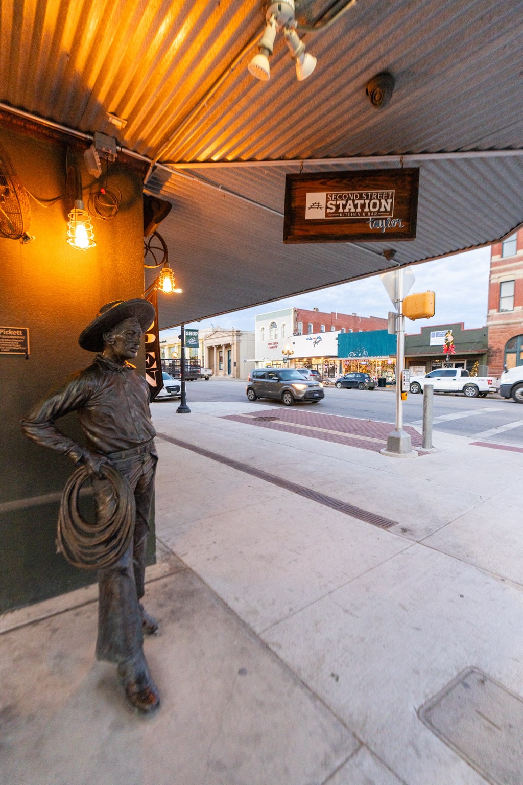 a statue of a cowboy standing on the side of a street at Mihir Taylor, Taylor, Texas