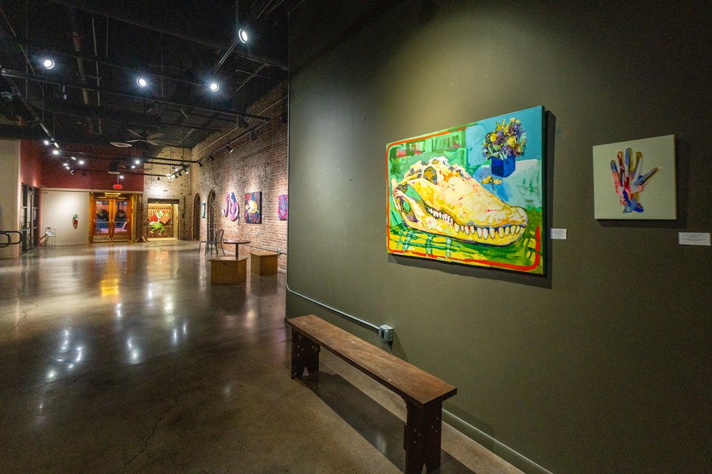 a gallery with a painting and a bench at Mihir Taylor, Taylor, Texas