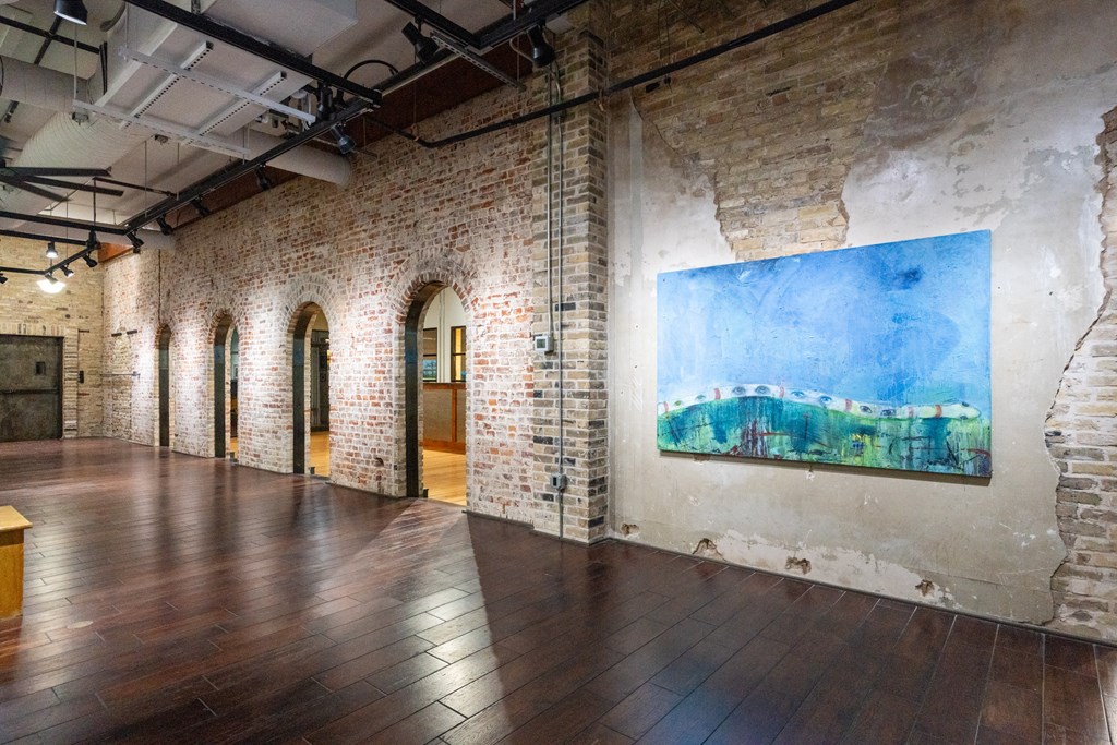a large room with wood floors and a painting on the wall at Mihir Taylor, Taylor, TX