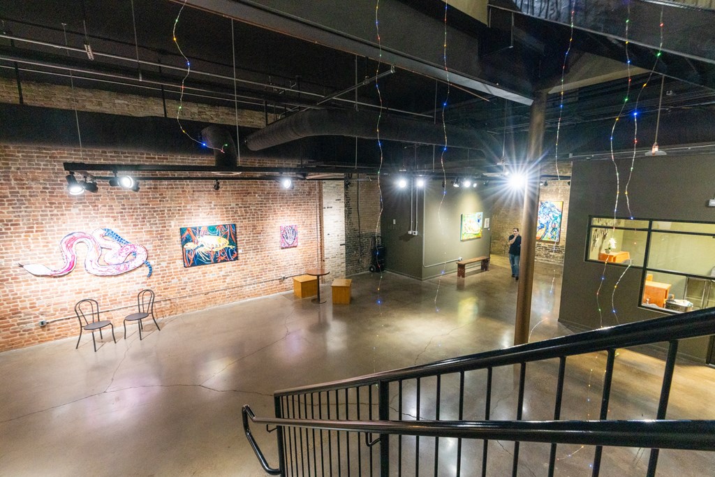 a large room with paintings on the wall and a staircase at Mihir Taylor, Taylor, TX 76574