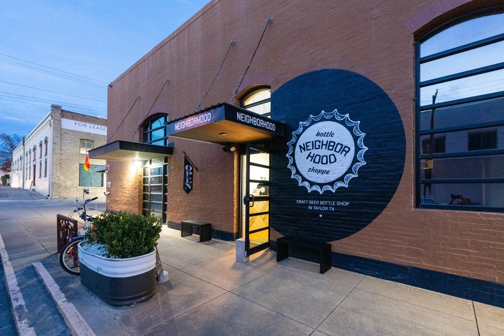 the outside of a brick building with a sign for the northeast road restaurant at Mihir Taylor, Taylor, 76574
